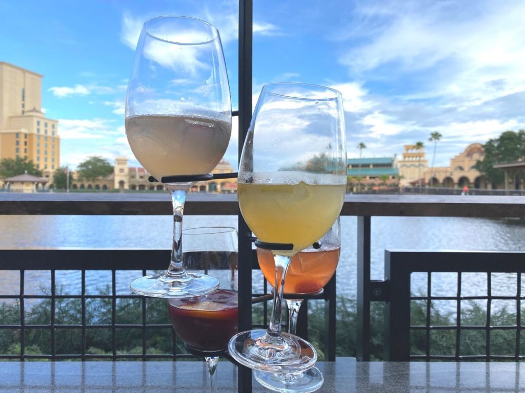 Sangria Flight with four small glasses of sangria and Disney's Coronado Springs Resort in the background