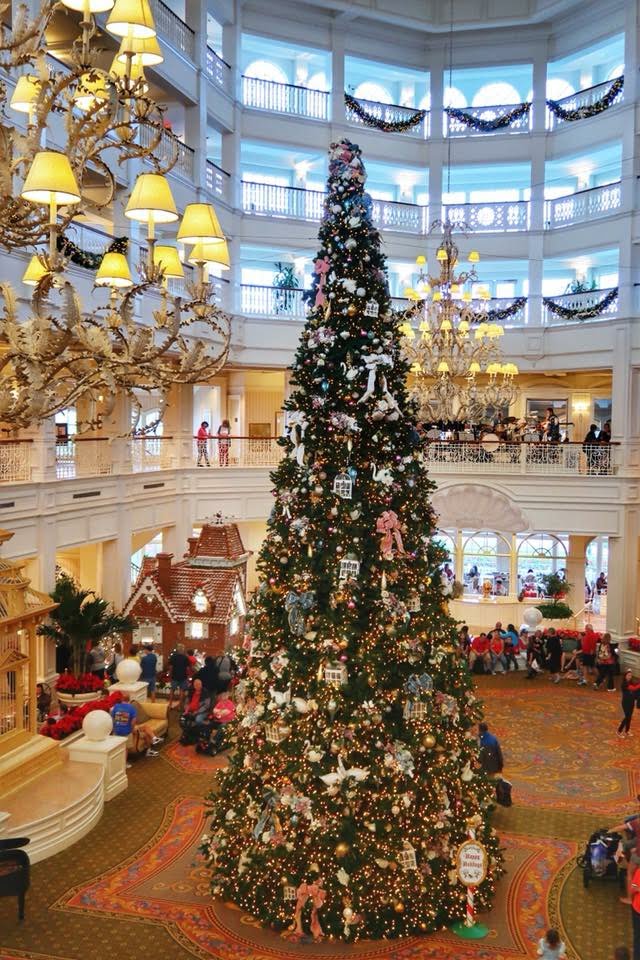 A towering christmas tree and garland decorate the Victorian inspired lobby of Disney's Grand Floridian Resort and Spa