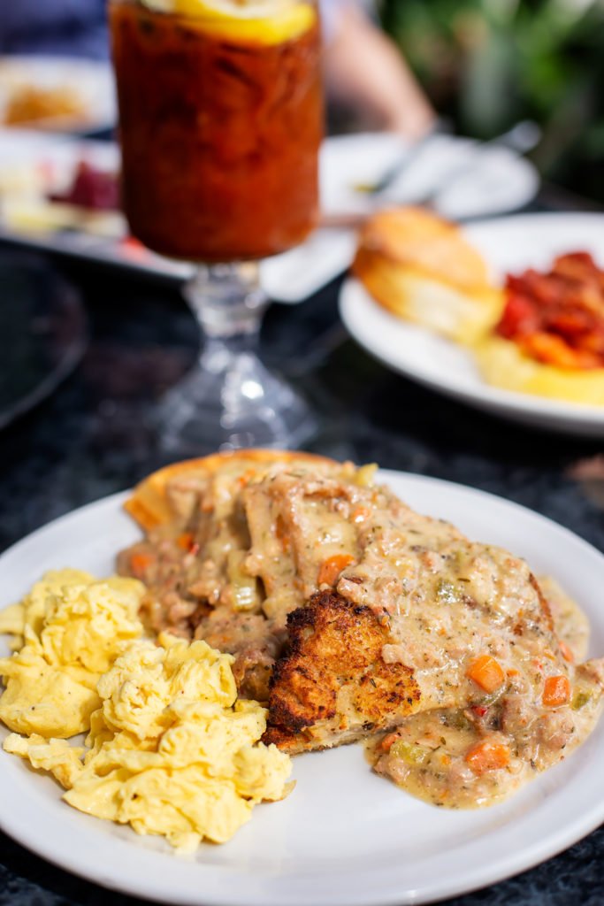a plate of toast, gravy, eggs, and bloody mary beverage at Brunch at Maxine's on Shine Orlando