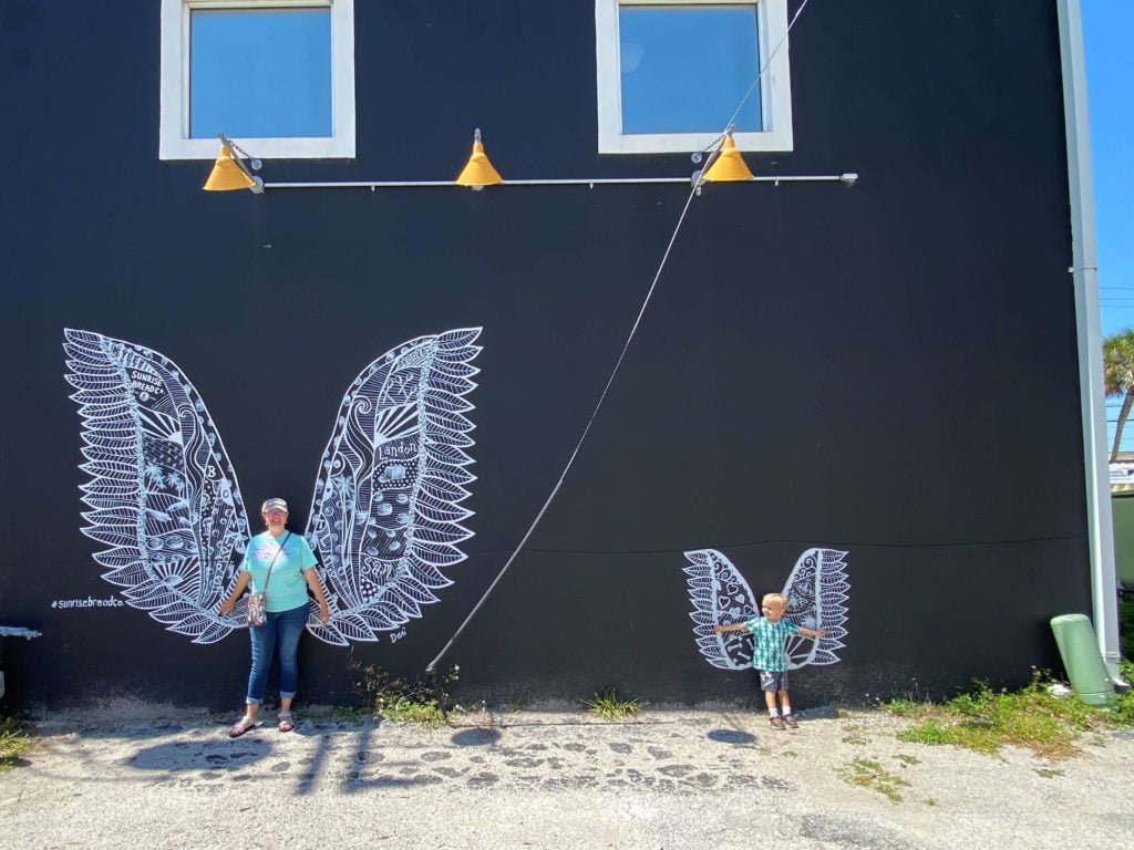 Wings mural at Sunrise Bread Company Titusville - black background with white wings