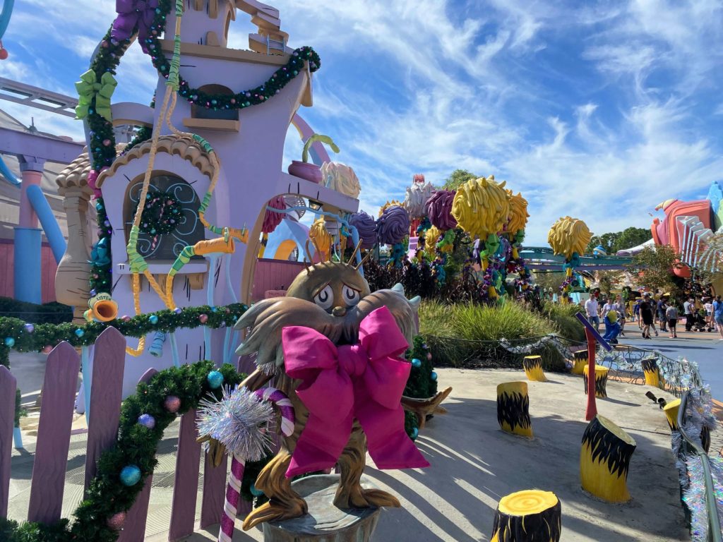 Brightly colored curvy buildings are child sized in the Lorax Forest at Seuss Landing in Islands of Adventure Decorated for Grinchmas