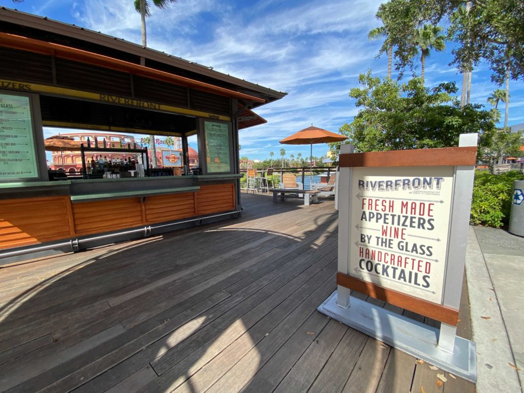 A large wooden deck is home to Riverfront Outdoor Bar at Universal Orlando CityWalk with relaxing lounge seating overlooking the water and CityWalk