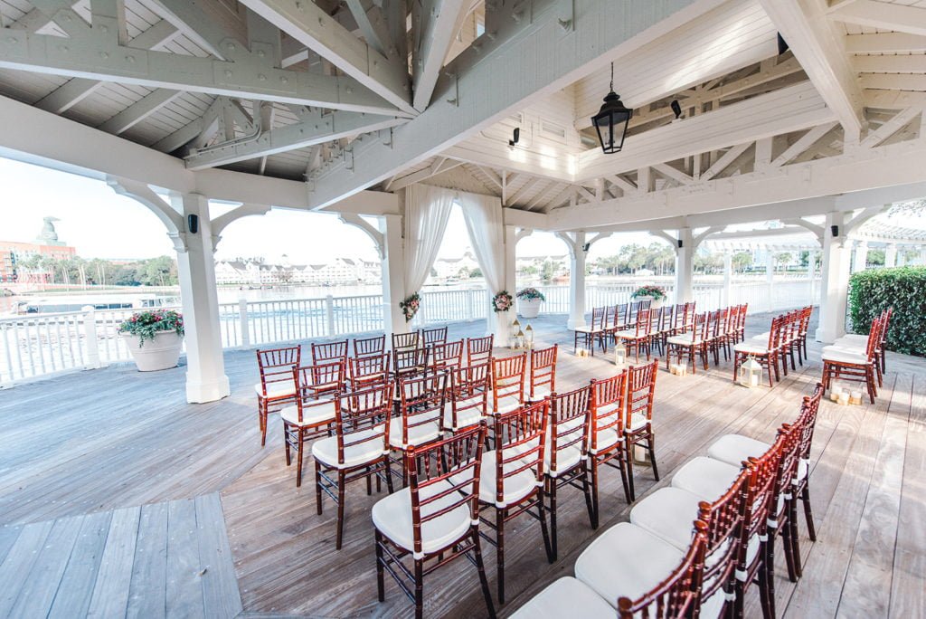 A wedding ceremony at Sea Breeze Point will transport couples and guests back to the 1920s with its timeless and romantic charm. This venue at Disney’s BoardWalk Inn sits on the shores of Crescent Lake at Walt Disney World Resort. Framed by sweeping arches, this waterside venue offers a peaceful place to say “I do.” This wooden pavilion has white beams across the ceiling with archways overlooking the water and a wooden boardwalk deck