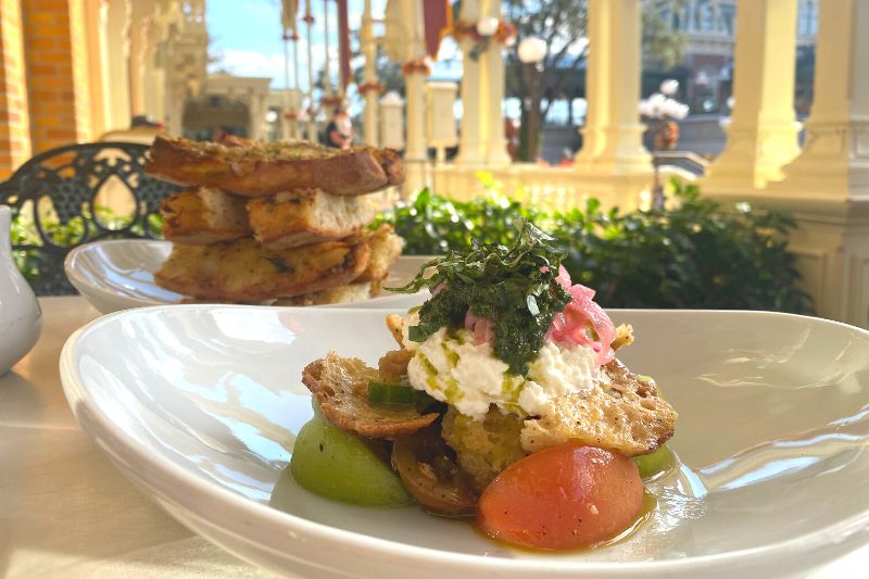 Tomato and burrata salad, garlic bread appetizer, sitting outside Tony's Town Square becomes a romantic restaurant at Disney's Magic Kingdom