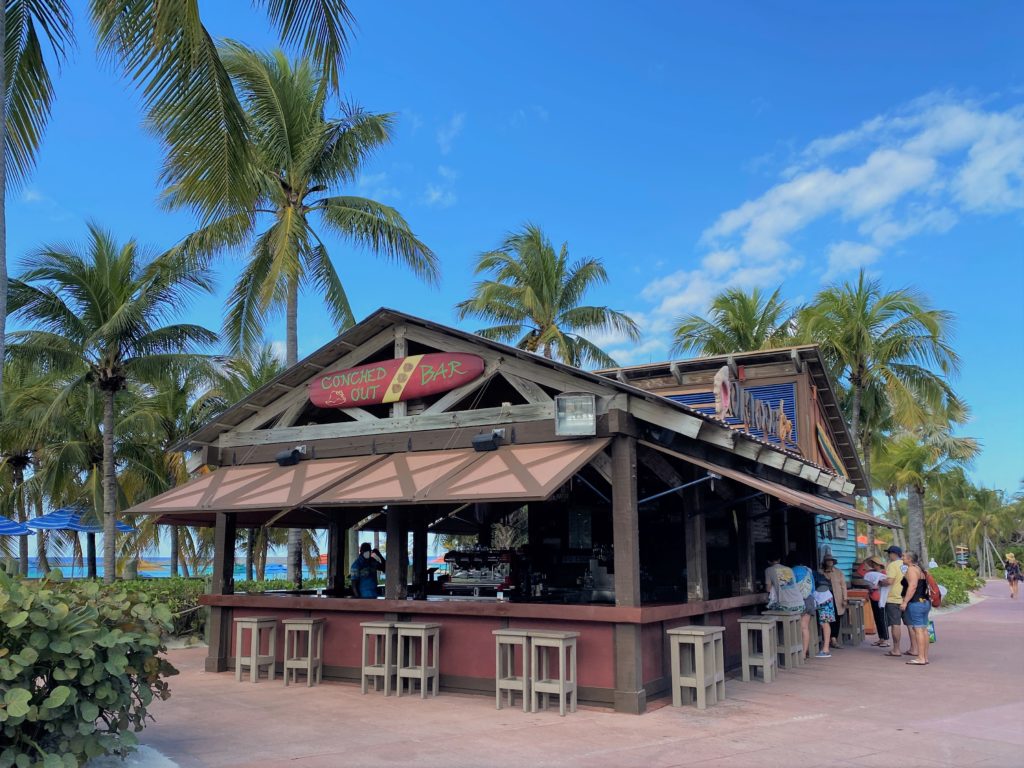 Conched Out Bar near main beach on Castaway Cay amid blue skies and lush palm trees