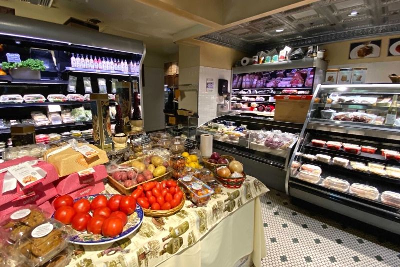 Antonio's Maitland - Italian Market and Cafe with red tomatoes and other produce in the foreground and a deli case in the background