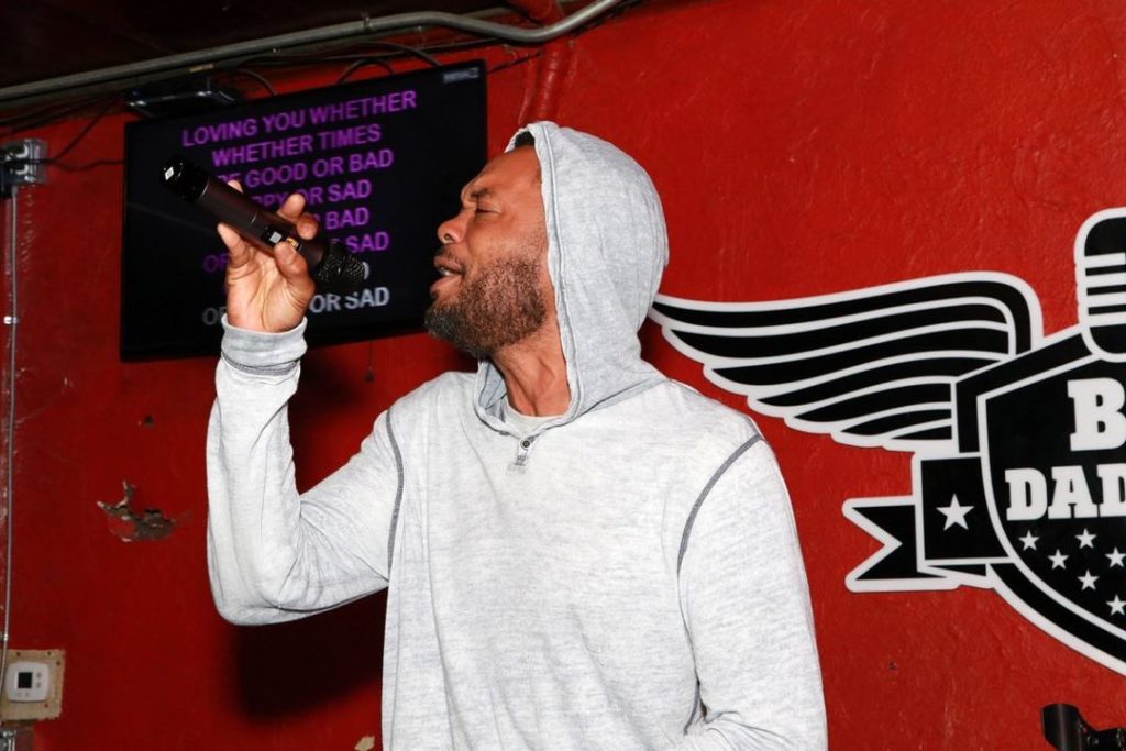 Man in grey hoodie singing at Big Daddy's Orlando Karaoke