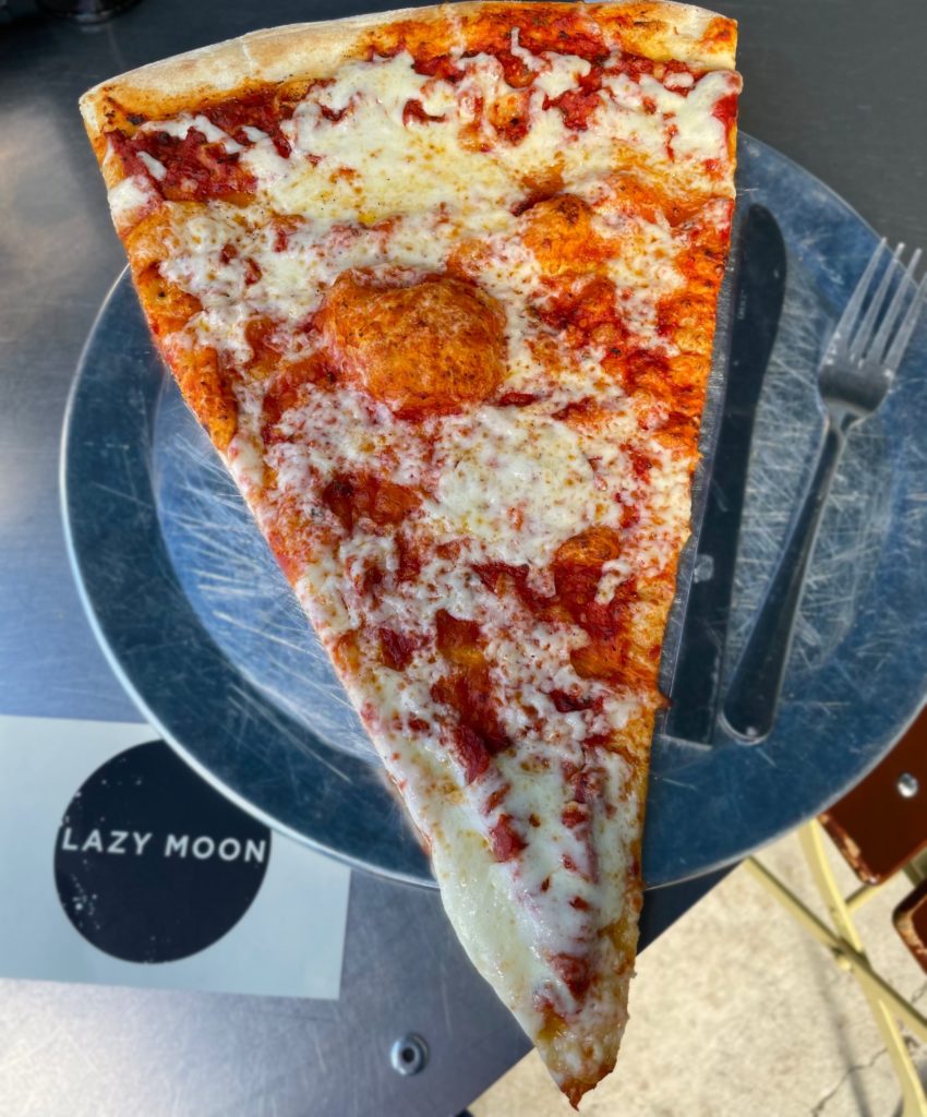 a slice of pizza from azy Moon Pizza orlando