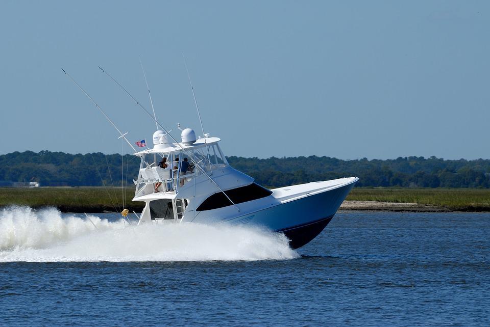 A large white yacht style boat cruises along on aCocoa Beach Fishing Charter - Inshore Indian River Lagoon