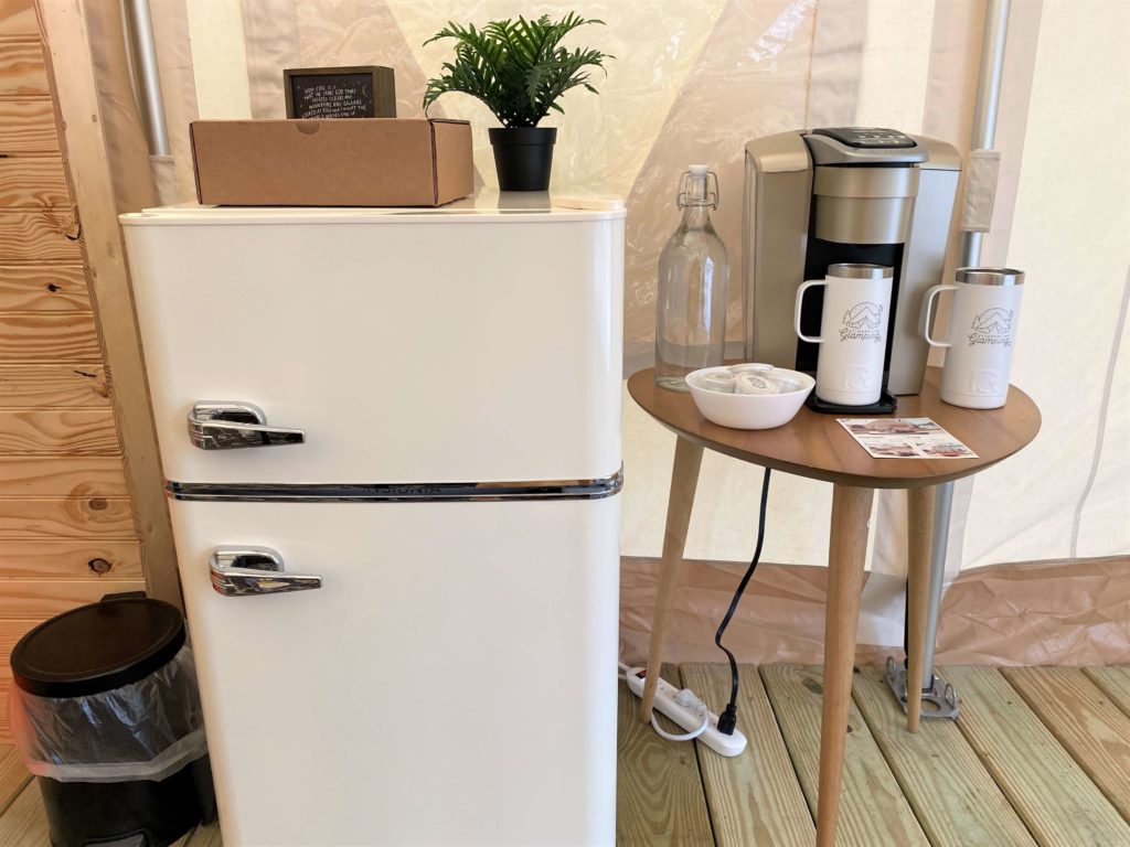 Mini refrigerator and coffee maker inside glamping tent