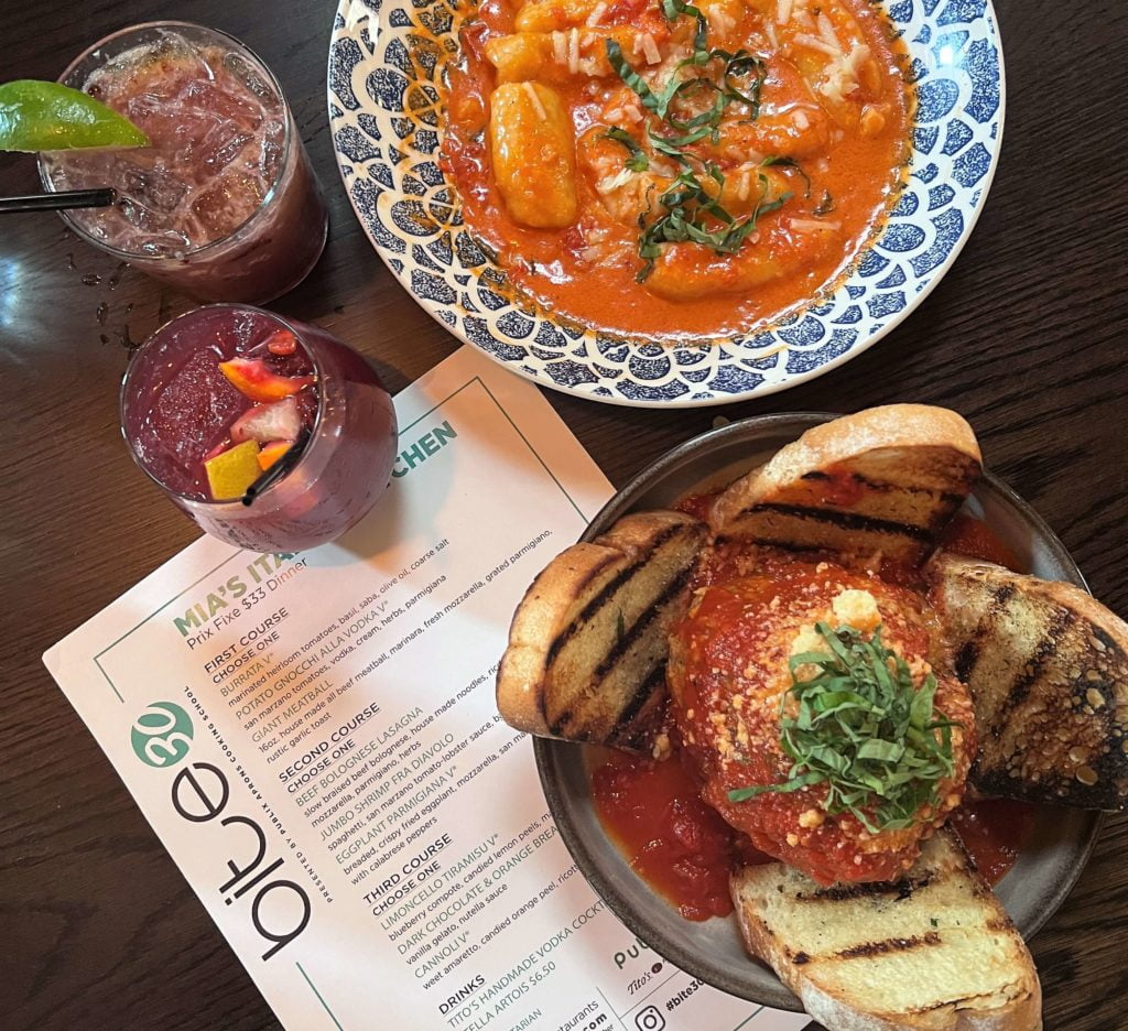 Bite 30 Orlando menu on table accompanied by Mia's Italian Kitchen food and drinks