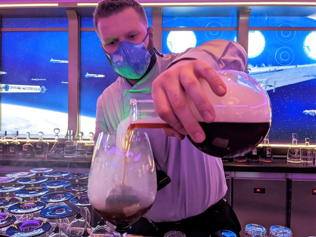 a bartender pours a Freetown Reserve Cocktail at Star Wars Hyperspace Lounge on Disney Wish