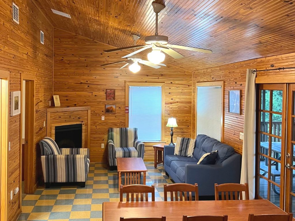 Lake Louisa State Park Cabins - Living Room with a couch, two chairs, ceiling fans, and dining table
