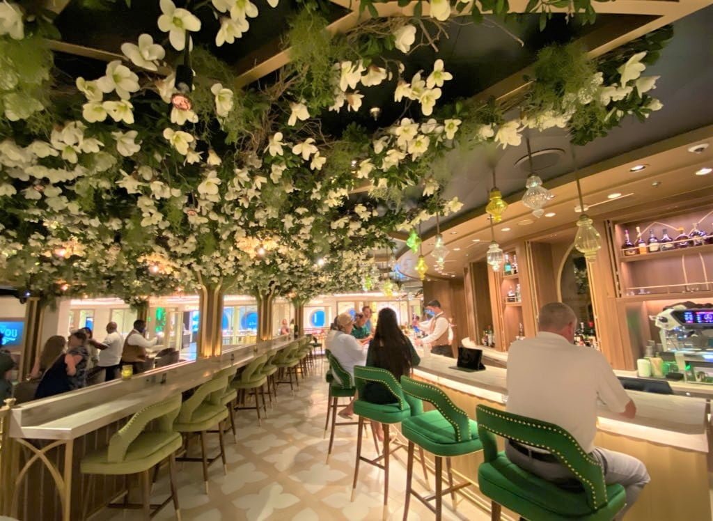 The Bayou Lounge on Disney Wish features a fake magnolia tree on the ceiling and rich green furnishings