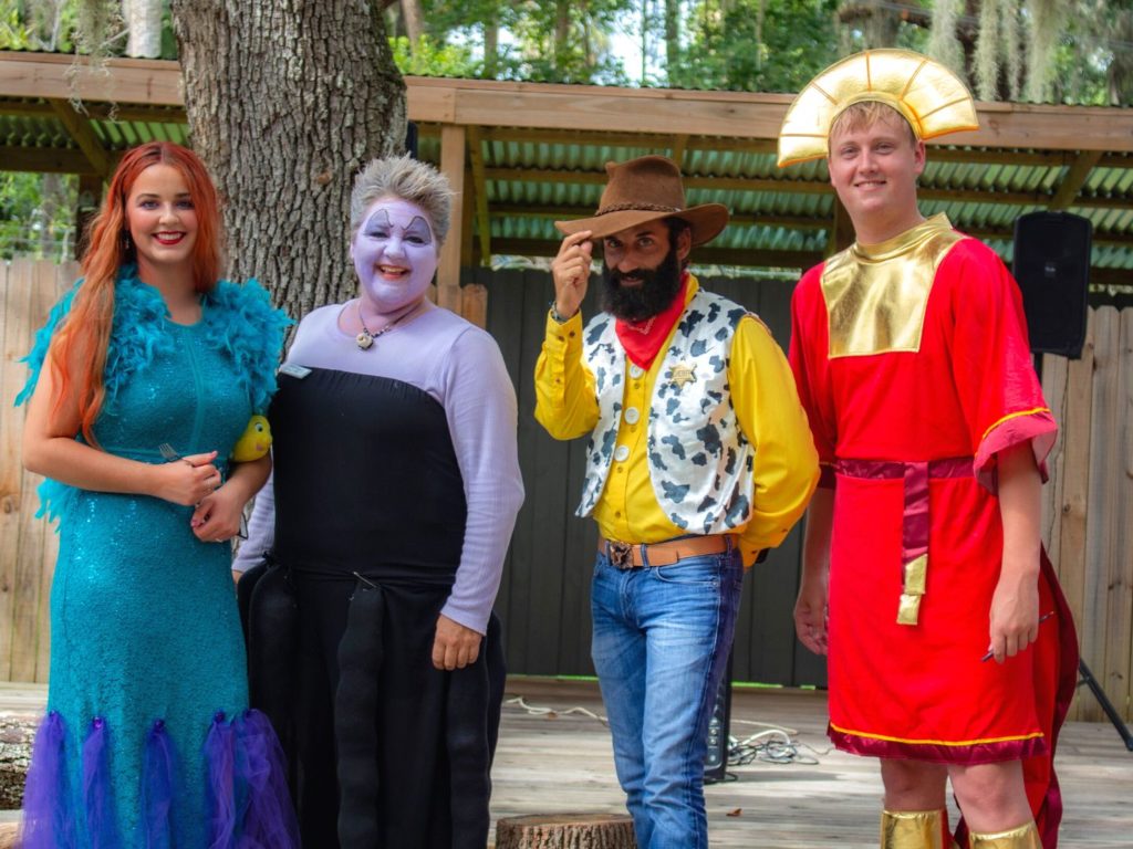 4 adults in disney costumes at Halloween in Orlando Boo Bash Image by Central Florida Zoo