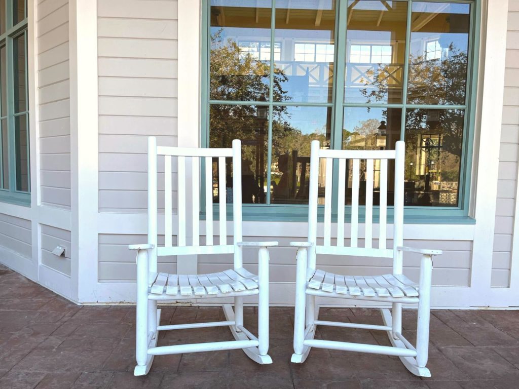 two white rocking chairs at the porch of the lobby building at disney's port orleans resort