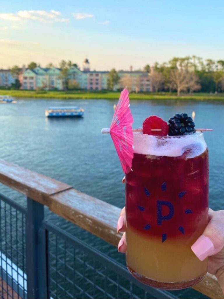 a tropical cocktail with a view of disney boats at Paddlefish Rooftop Bar and Restaurant Disney Springs