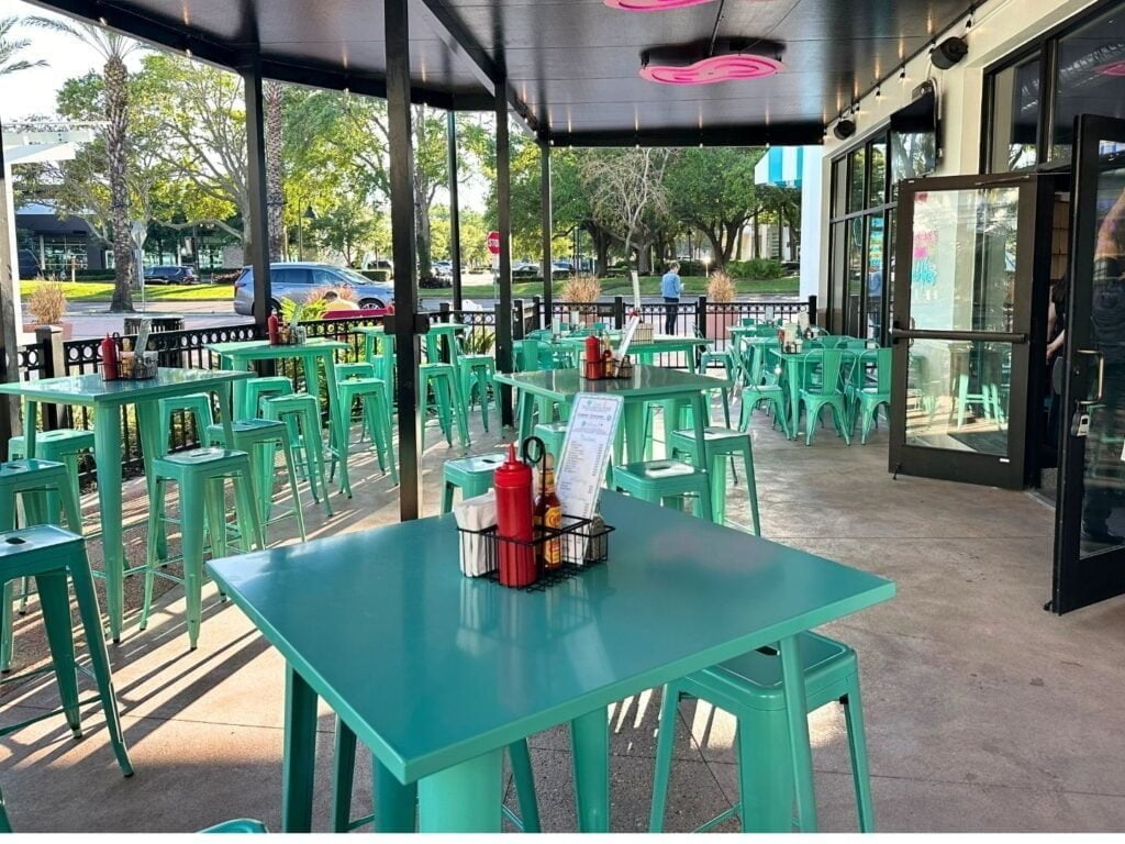 Outdoor Dining at JoJo's Shake BAR Orlando features turquoise colored tables and chairs