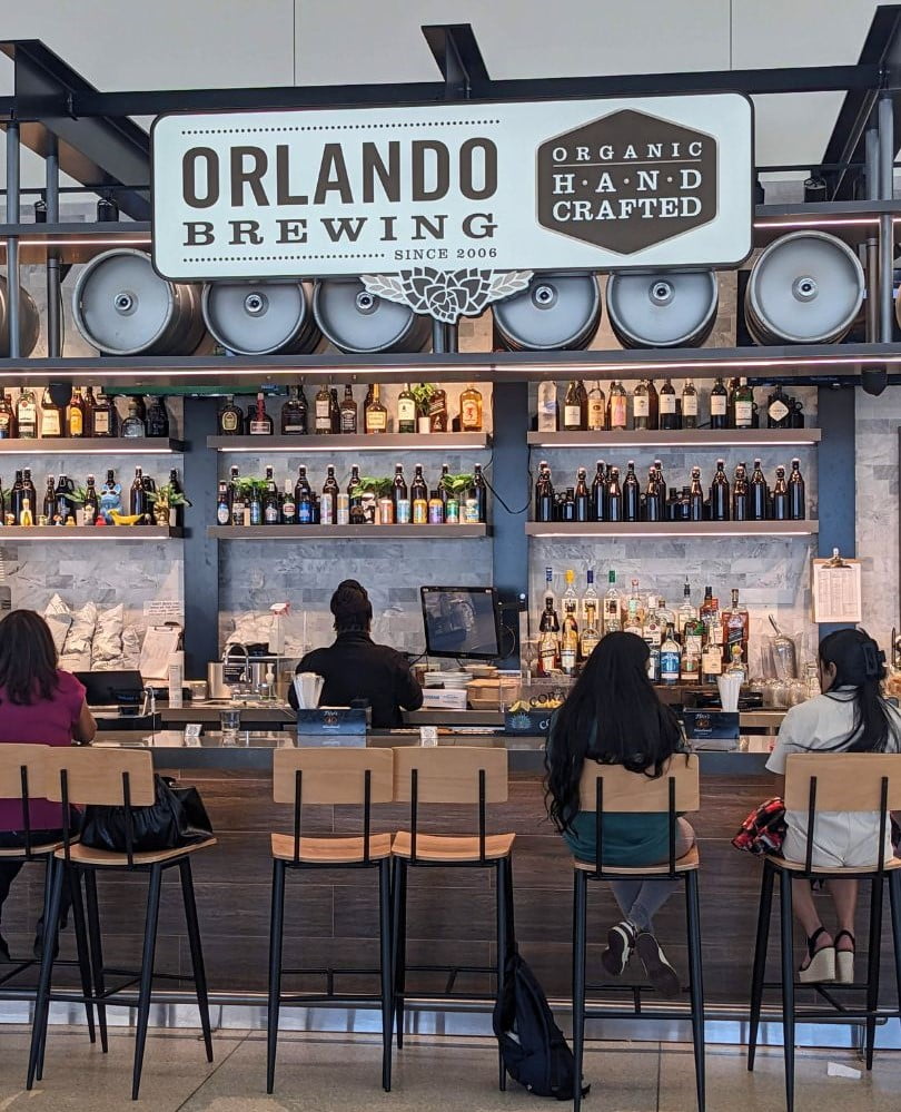 guests sit at bar of Orlando Brewing Airport Terminal C 