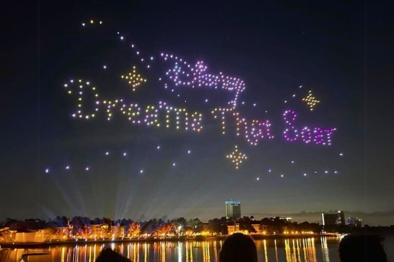 Drones making the shape of the Disney Dreams That Soar logo above Disney Springs